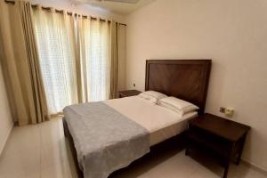 a bedroom with a large bed and a large window at Capital TRUST Residencies Colombo 05 in Colombo