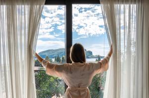a woman is looking out of a window at Iberostar Waves Slavija in Budva