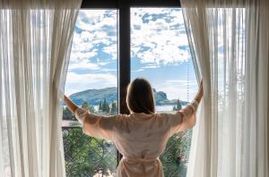 een vrouw kijkt uit een raam bij Iberostar Slavija in Budva
