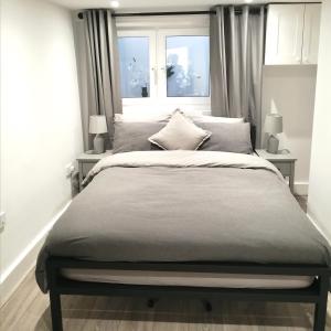 a bedroom with a large bed with two windows at Brighton Palms in Brighton & Hove