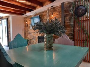a green table with a vase of flowers on it at Ribança Village in Destriz