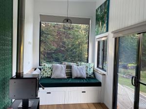 a window seat in a tiny house with a green bench at Little Pardalote Tiny Home Bruny Island in Alonnah