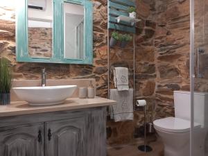 a bathroom with a sink and a toilet and a mirror at Ribança Village in Destriz +46 photos