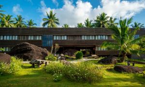 a building with palm trees in front of it at Natuna Dive Resort in Ranai