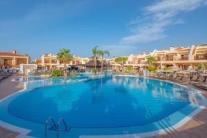 a large pool at a resort with chairs and condos at Royal Sunset Beach Club in Adeje
