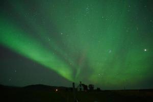 een noorderlicht in de nacht met een huis bij Álftártunga Farm Guesthouse in Borgarnes