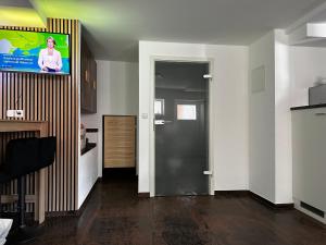 een woonkamer met een flatscreen-tv aan de muur bij Dominik in Dernbach