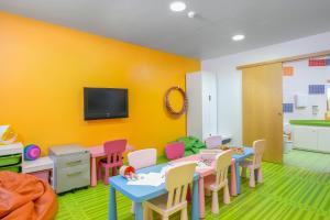 a room with tables and chairs and a tv on a wall at Royal Sunset Beach Club in Adeje