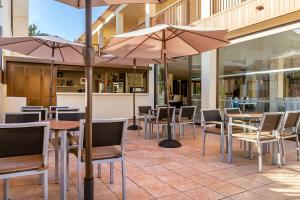 a restaurant with tables and chairs and umbrellas at Royal Sunset Beach Club in Adeje