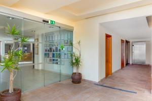 a lobby with glass doors and potted plants at Royal Sunset Beach Club in Adeje