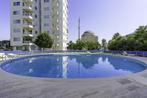 a large blue swimming pool in front of a building at Flat w Pool Garden 3 min to Beach in Antalya in Antalya