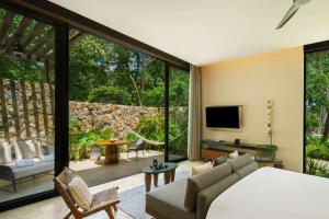 a bedroom with a bed and a large glass window at Hacienda Xcanatun, Angsana Heritage Collection in Mérida