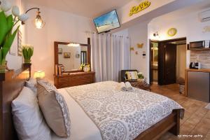 ein Schlafzimmer mit einem großen weißen Bett und einem Spiegel in der Unterkunft פנינת עוז - מתחם נופש יוקרתי in Oshrat