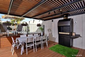 a patio with a table and chairs and a grill at פנינת עוז - מתחם נופש יוקרתי in Oshrat