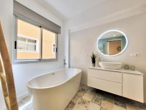 une salle de bain blanche avec une baignoire et un miroir dans l'établissement Plaza y Playa, à Puerto de la Cruz