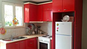 a kitchen with red cabinets and a white refrigerator at Rezenda in Kala Nera