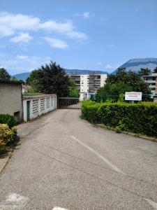 an empty parking lot with a fence and buildings at L'Edelweiss Campus & Parking privé securisé in Gières