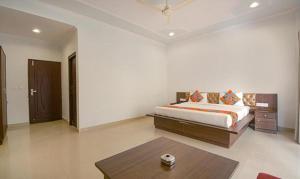a bedroom with a bed and a table in it at FabHotel Yamunotri Retreat, Tapovan in Rishīkesh
