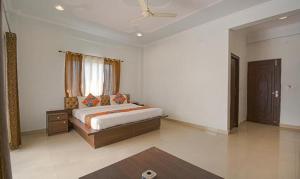 a white bedroom with a bed and a window at FabHotel Yamunotri Retreat, Tapovan in Rishīkesh