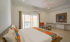 a bedroom with a large white bed and a desk at FabHotel Yamunotri Retreat, Tapovan in Rishīkesh