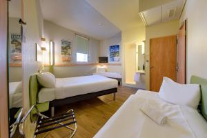 a hotel room with two beds and a bathroom at ibis budget Hotel Luzern City in Lucerne