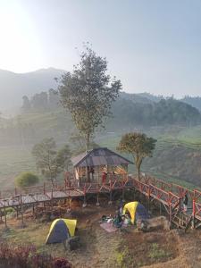 a group of tents on a hill with a bridge at Gunung bangku ciwidey rancabali camp in Ciwidey