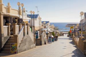 a street next to the beach with buildings and the ocean at Royal Sunset Beach Club in Adeje