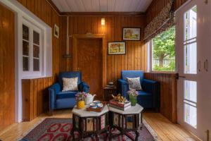 sala de estar con 2 sillas azules y mesa en LohonoStays Villa Hill Retreat, en Pahalgām