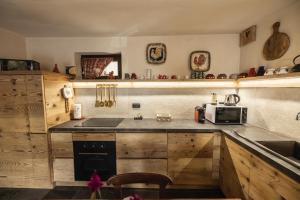 a kitchen with wooden cabinets and a sink and a microwave at La Casa del cuore in Fenis