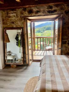 a bedroom with a large mirror and a balcony at APARTAMENTOS KERCUS in Sevares