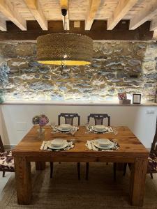 a wooden table with four chairs and aendant light at APARTAMENTOS KERCUS in Sevares +36 photos