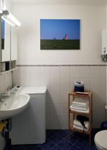 een badkamer met een wastafel, een toilet en een spiegel bij Blinkfüer am Kap Arkona in Putgarten