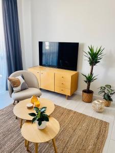 a living room with a television and two tables at BeeApartments Naściszowska 18 in Nowy Sącz