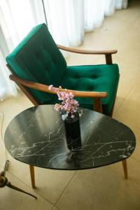 una mesa de cristal con un jarrón de flores en una silla en Loft 35a, en Tesalónica