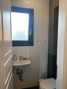 baño con lavabo y aseo y ventana en Loft 35a, en Tesalónica