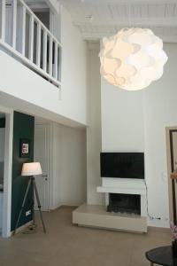 sala de estar con TV y lámpara de araña en Loft 35a, en Tesalónica