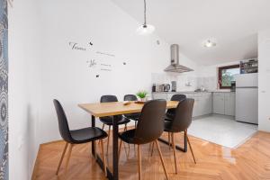 uma cozinha e sala de jantar com uma mesa de madeira e cadeiras em Apartment Gracia with private parking and free internet em Porec
