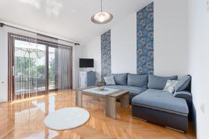 uma sala de estar com um sofá azul e uma mesa em Apartment Gracia with private parking and free internet em Porec
