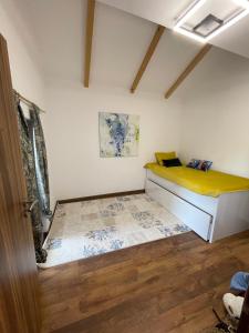 1 dormitorio con 1 cama con colchón amarillo en Villa fg, en Gnjilane