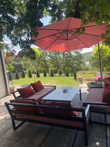 a patio with a red umbrella and a table at Villa fg in Gjilan