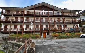 un grand bâtiment avec une voiture garée devant dans l'établissement Maison 4Emme, à La Thuile