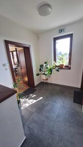 an empty room with potted plants and a window at Apartmány Zaky in Vrbov
