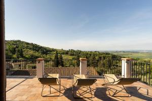 - un ensemble de chaises assises sur une terrasse avec vue dans l'établissement BORGO SMOL, à Chianni