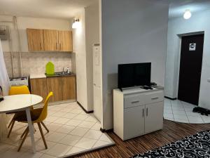 a living room with a tv and a table and a kitchen at Ухоженная и уютная квартира!!! in Tiraspol