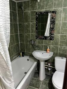 a bathroom with a tub and a sink and a toilet at Ухоженная и уютная квартира!!! in Tiraspol