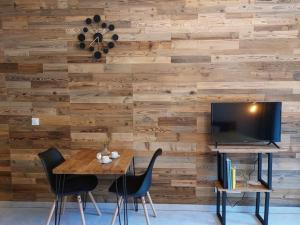 a dining room with a wooden wall with a tv at Mountain Lodge Studio Forset View in Szklarska Poręba