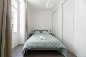 a bedroom with a bed with a green blanket at Le Brit - Grand appartement design, 3 chambres, centre ville in Vichy +48 photos