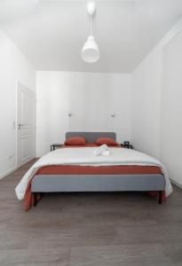una camera bianca con un grande letto con cuscini rossi di Le Brit - Grand appartement design, 3 chambres, centre ville a Vichy Altre 48 foto