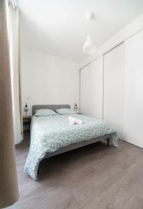a bedroom with a bed in a white room at Le Brit - Grand appartement design, 3 chambres, centre ville in Vichy