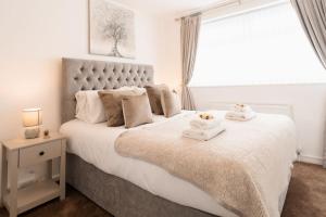 a bedroom with a large bed with towels on it at Prenton House, 3BR Close to Liverpool in Birkenhead